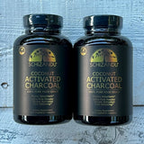 Two bottles of Schizandu Coconut Activated Charcoal on a textured surface