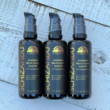 Three bottles of undiluted black cumin seed oil on a wooden surface.