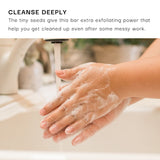 Person washing hands with soap under running water, with text about exfoliating power.