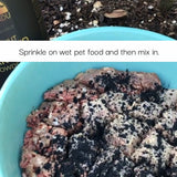 Pet food with black specks sprinkled on top, text overlay 'Sprinkle on wet pet food and then mix in.'
