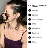 Woman applying a facial mask with a list of ingredients she does not contain on the right.