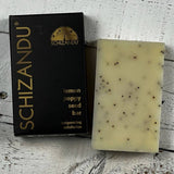 Schizandu lemon poppy seed bar soap next to its packaging on a wooden surface