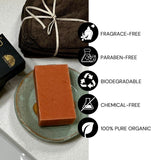 Bar of soap on a plate with certification icons for fragrance-free, paraben-free, biodegradable, chemical-free, and 100% pure organic on a white background.
