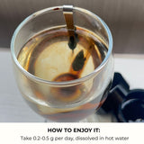 A glass of liquid with a resin spoon, accompanied by text on how to enjoy it.
