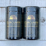 Two containers of Schizandu Curcumin on a wooden surface