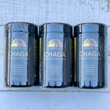 Three bottles of Chaga supplement on a wooden surface