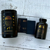 Two black containers of Schizandu activated charcoal powder on a wooden surface.