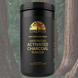 Black container of hardwood activated charcoal powder with Schizandu branding against a natural background.