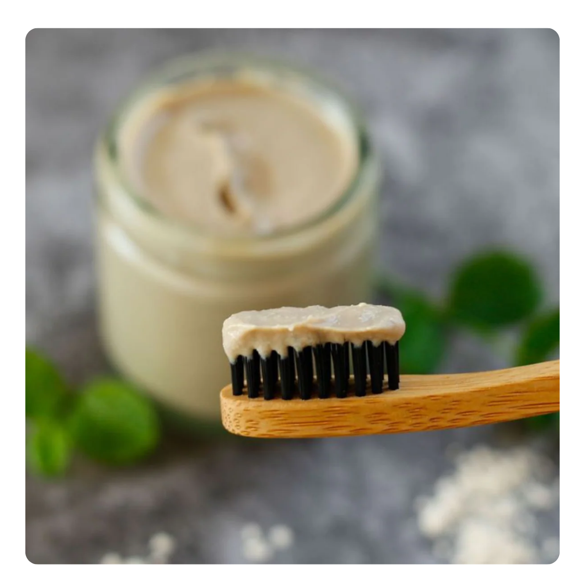 Bamboo toothbrush with toothpaste on a gray background