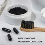 Black charcoal powder in a container with a toothbrush and capsules on a white background, labeled 'PURE CHARCOAL POWER FOR ORAL CARE'.