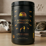 Black container of Schizandu Activated Charcoal for Greyhounds and their friends on a wooden surface with pets in the background.