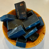 Schizandu charcoal detox bars in a wooden basket with packaging on a beige background