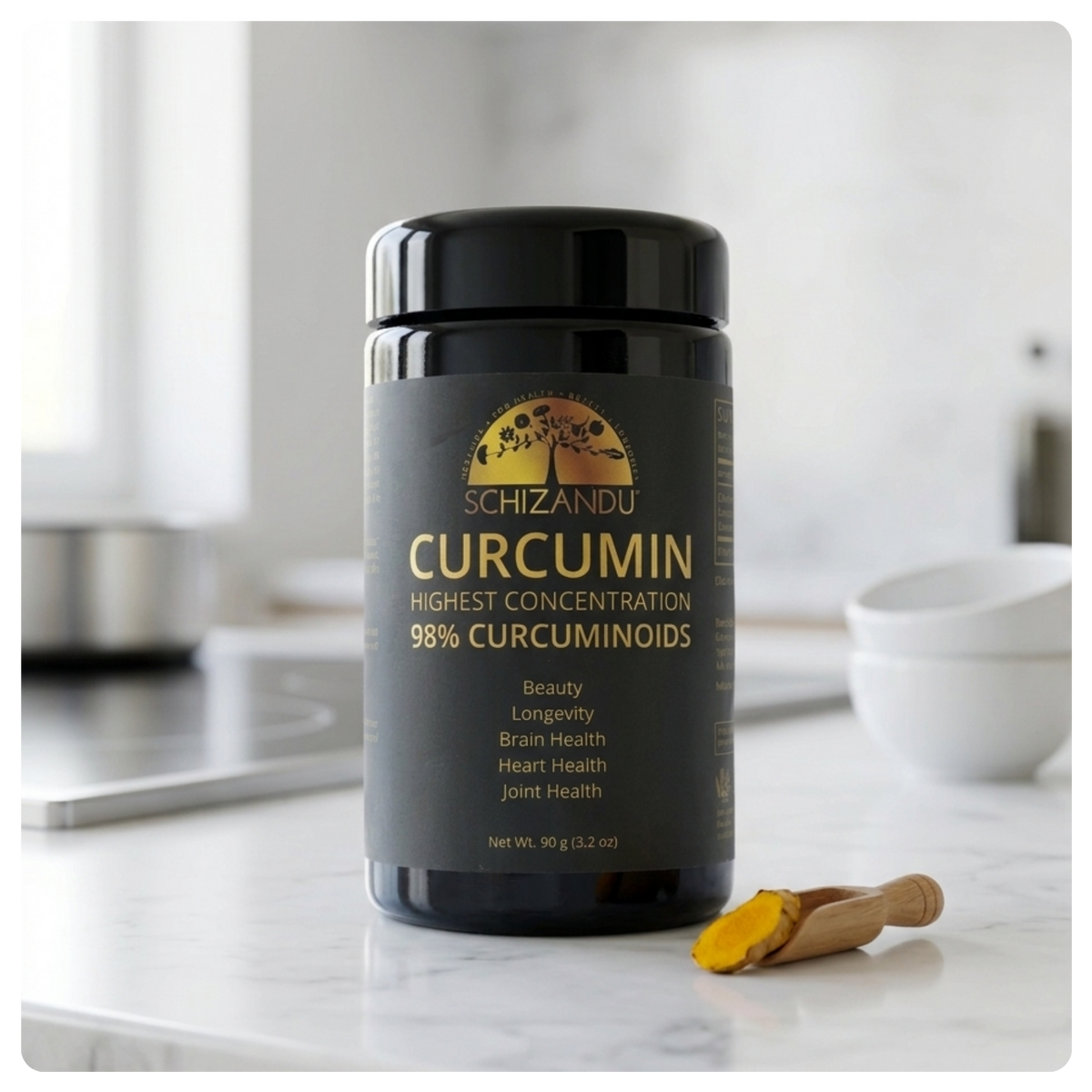 A black plastic jar of Schizandu Curcumin powder on a white marble countertop with a small wooden spoon holding yellow turmeric powder in the foreground. The background is a softly blurred kitchen setting.