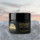 A black jar of Schizandu Shilajit Raw Live Resin centered over a scenic mountain background with a soft pink and gray sky.