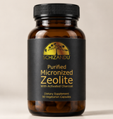 An amber glass bottle of Schizandu Purified Micronized Zeolite dietary supplement with a black ribbed cap and a black label featuring gold text and logo, set against a neutral beige background.